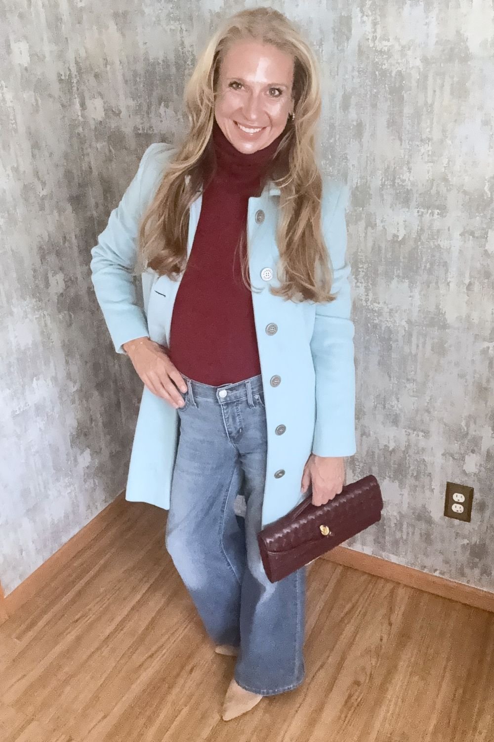 Burgundy turtleneck under a greyed ice-blue coat
