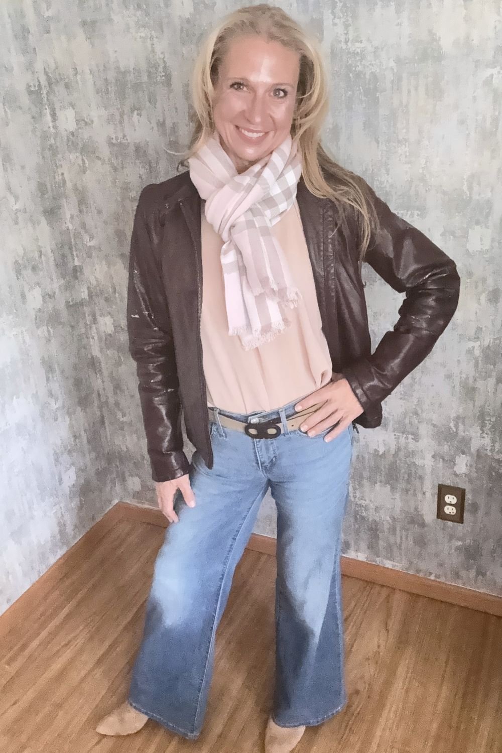 Burgundy leather jacket with a pale rose scarf, worn with denim