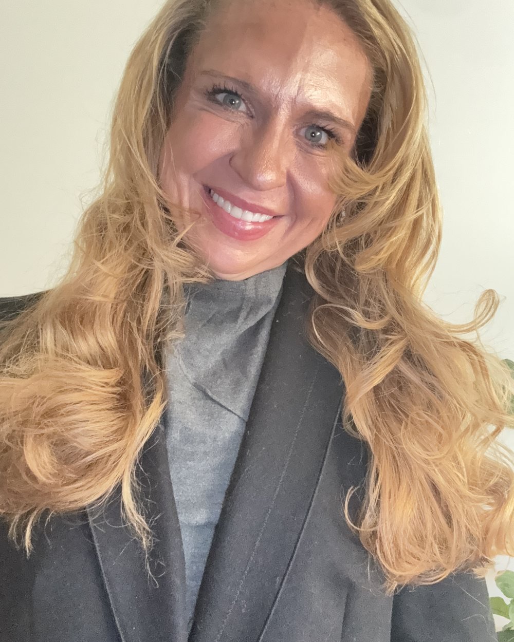Heather in a black coat over a grey turtleneck