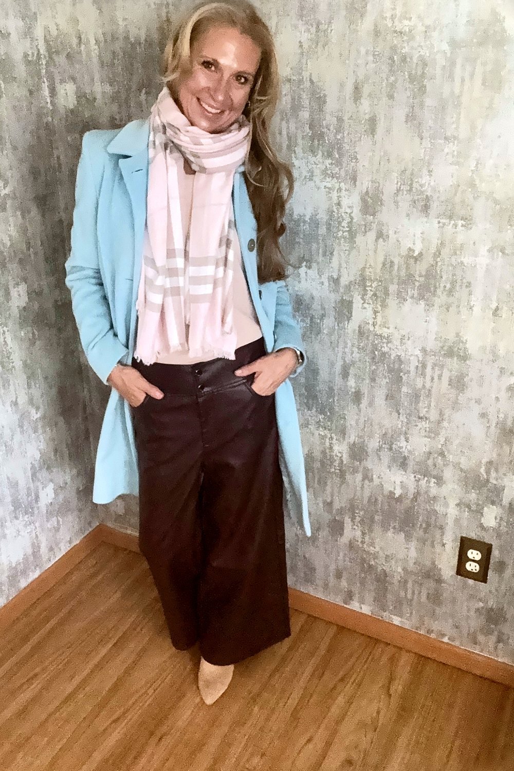 Heather in a powder blue wool coat over wine leather wide-leg pants, with a soft pink plaid scarf